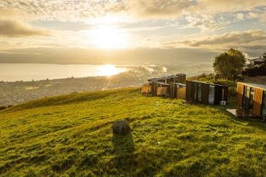 Tiny Away cabins on a hillside above Rotorua at sunset